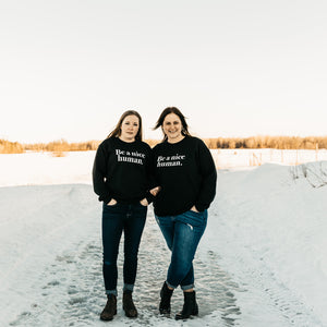 Christine and Lyndsay, owner of wild child apparel. Smiling and wearing be a nice human shirt.