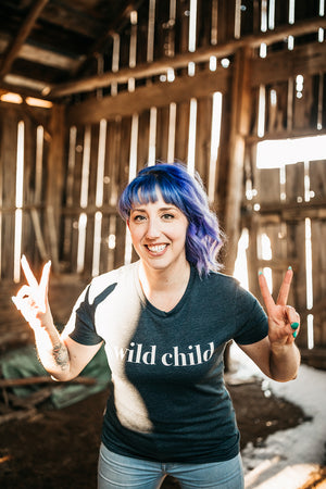 woman smiling at camera in barn wearing t shirt 